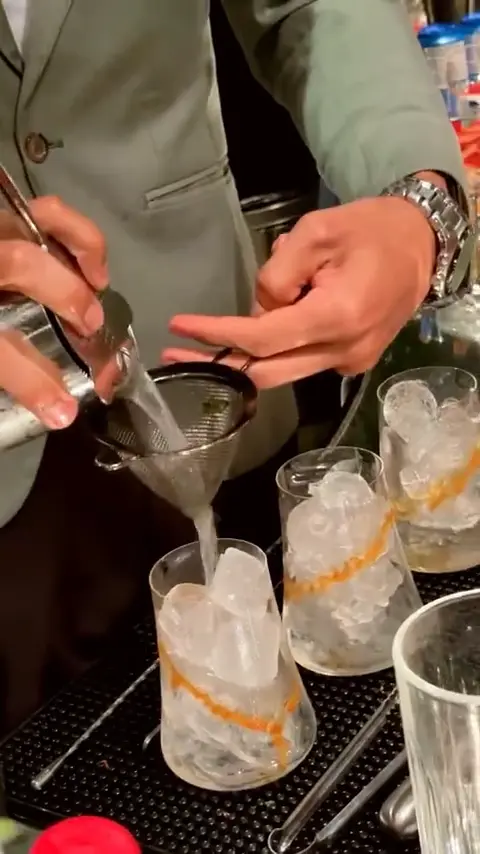 Bartender coando um coquetel sobre gelo